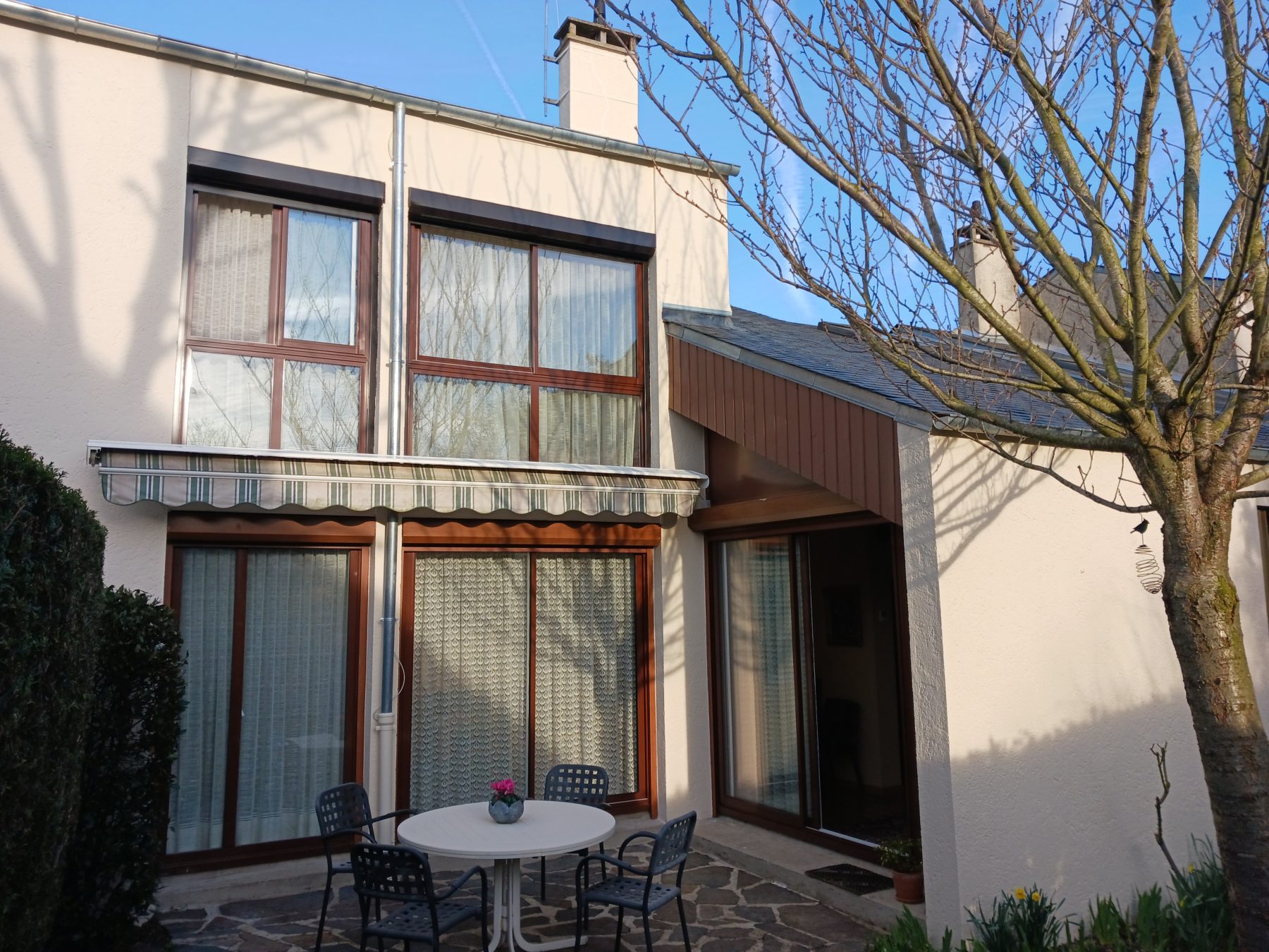 Façade de maison avec enduit clair et baies vitrées, Raval d'Oise