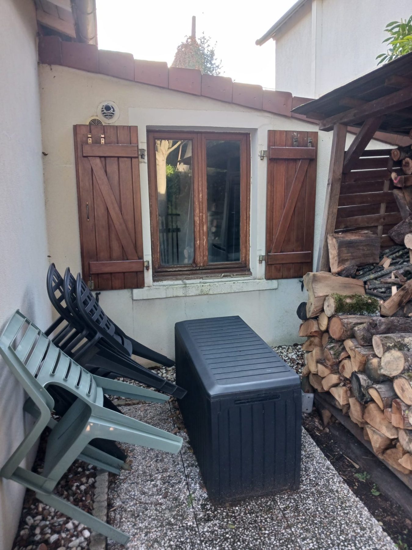 Fenêtre avec volets en bois sur façade à ravaler, Raval d'Oise