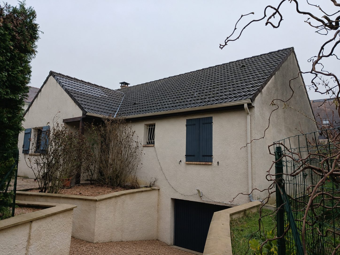 Maison individuelle avec façade crépie et volets bleus à Raval d'Oise
